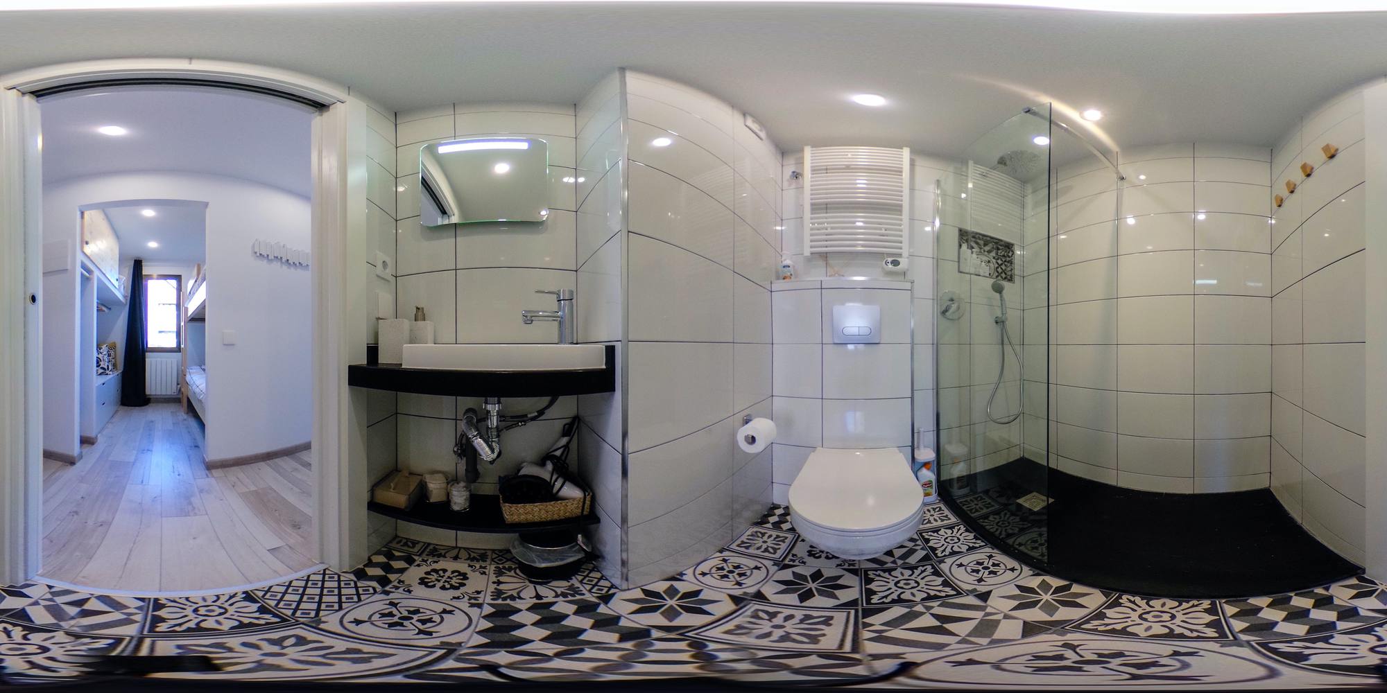 Bany després: dutxa, moble de lavabo, enrajolat gràfic